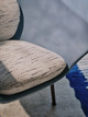 Close-up of Drizzle Indigo upholstered chair, highlighting tonal woven stitches and sunlight casting shadows across the textured fabric.